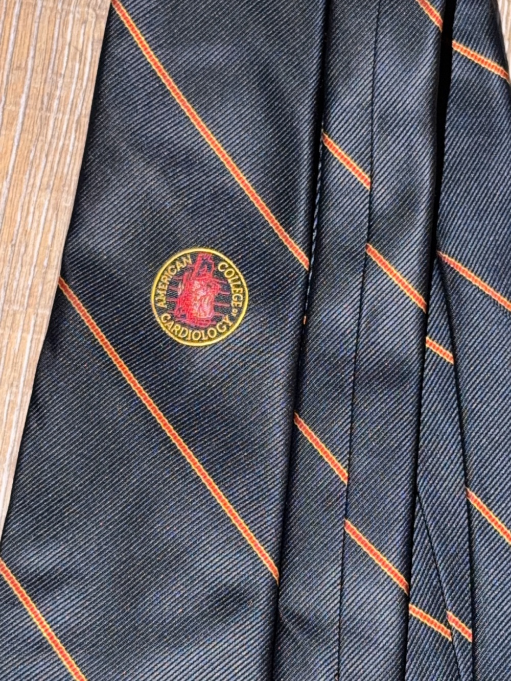 Navy Tie with Orange Diagonal Stripes and Embroidered Crest